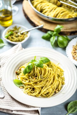 Fesleğen krem ve peynirli makarna spagetti. Üstten görünüm gri taş masada. Sebze vejetaryen makarna.