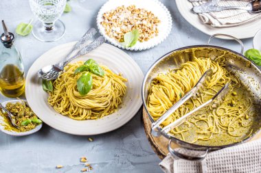 Fesleğen krem ve peynirli makarna spagetti. Üstten görünüm gri taş masada. Sebze vejetaryen makarna.