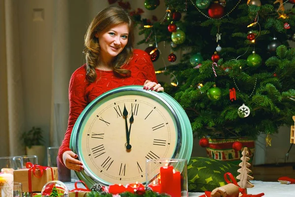 クリスマスに目覚まし時計と赤いセーターの少女の肖像画の背景をライトします — ストック写真