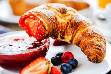 Kahve, portakal suyu, kruvasan, tahıl ve meyve ile kahvaltı. Dengeli beslenme.