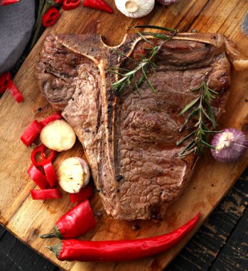  T-Bone biftek görmüş baharat ve taze otlar ile ahşap bir gemide görev yaptı.