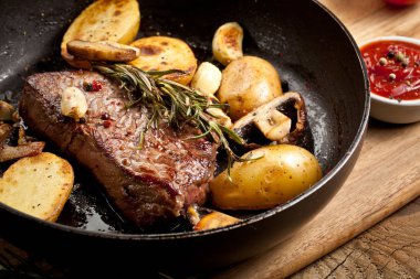 Izgara siyah Angus biftek kızartma ahşap arka plan üzerinde dökme demir ızgara tava üzerinde Striploin