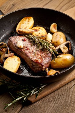 Izgara siyah Angus biftek kızartma ahşap arka plan üzerinde dökme demir ızgara tava üzerinde Striploin