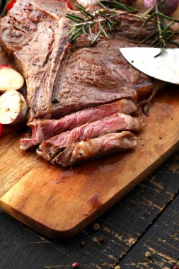  T-Bone biftek görmüş baharat ve taze otlar ile ahşap bir gemide görev yaptı.