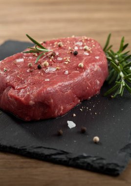 Koyu ahşap masada çiğ biftek..