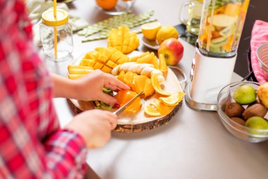 Genç gülümseyen kadın evde mutfak blender Smoothie taze yeşillikleri ile yapma.