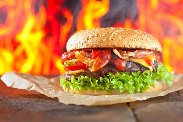 Close-up of home made burgers with fire flames.