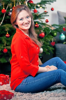 Mutlu kadın evde oturma odasında bir Noel ağacı süsleme