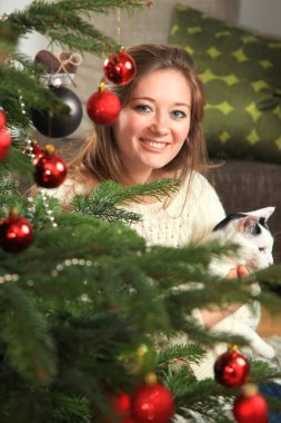 Mutlu kadın evde oturma odasında bir Noel ağacı süsleme