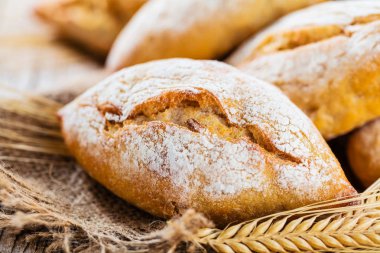 Ahşap masa üzerinde taze ekmek çeşitleri. İzole kahverengi zemin üzerine ekmek çeşitliliği.