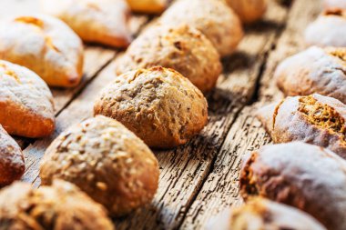 Ahşap masa üzerinde taze ekmek çeşitleri. İzole kahverengi zemin üzerine ekmek çeşitliliği.