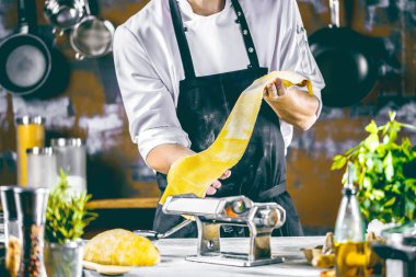 Makarna Erişte makarna makinesi mutfak masasında bazı malzemelerle yapma Şef. 