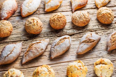 Ahşap masa üzerinde taze ekmek çeşitleri. İzole kahverengi zemin üzerine ekmek çeşitliliği.