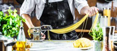 Makarna Erişte makarna makinesi mutfak masasında bazı malzemelerle yapma Şef. 