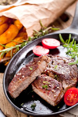 Siyah taştan arka planda patates ve orta pişmiş biftek. Üst manzara, düz uzanma