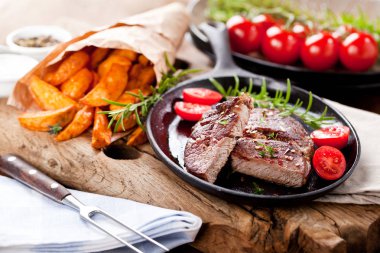 Siyah taştan arka planda patates ve orta pişmiş biftek. Üst manzara, düz uzanma