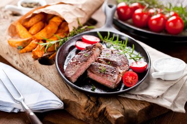 Siyah taştan arka planda patates ve orta pişmiş biftek. Üst manzara, düz uzanma