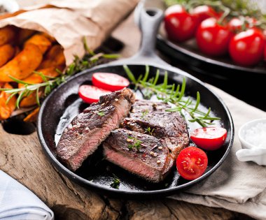 Siyah taştan arka planda patates ve orta pişmiş biftek. Üst manzara, düz uzanma