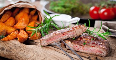 Siyah taştan arka planda patates ve orta pişmiş biftek. Üst manzara, düz uzanma