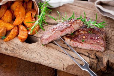 Siyah taştan arka planda patates ve orta pişmiş biftek. Üst manzara, düz uzanma