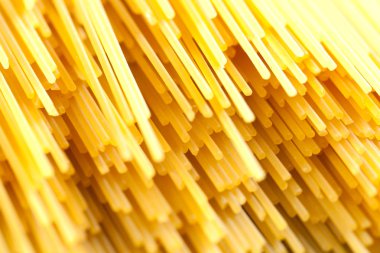 Rustik bir arka plan üzerinde sarı uzun spagetti. Sarı İtalyan makarna. Uzun spagetti.