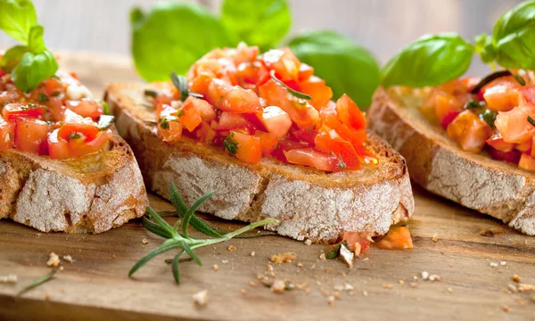 Bruschetta Plakjes Geroosterde Stokbrood Gegarneerd Met Basilicum — Stockfoto