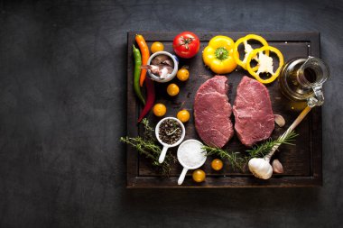 Koyu ahşap masada çiğ biftek..