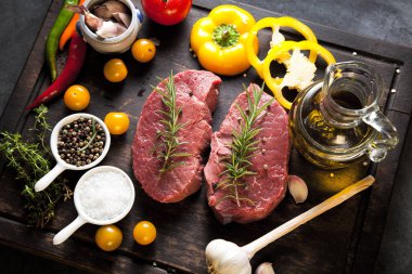 Koyu ahşap masada çiğ biftek..