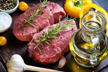 Koyu ahşap masada çiğ biftek..