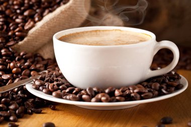 fincan kahve ve kek üzerine kahve çekirdekleri.