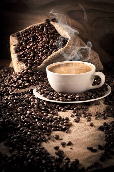 cup of coffee and  cake on coffee beans.