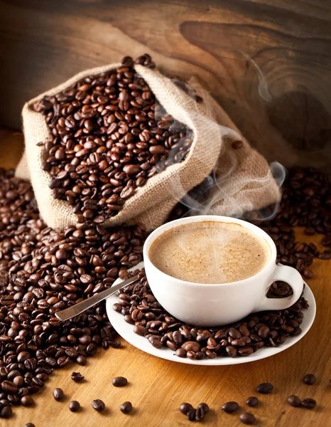 cup of coffee and  cake on coffee beans.