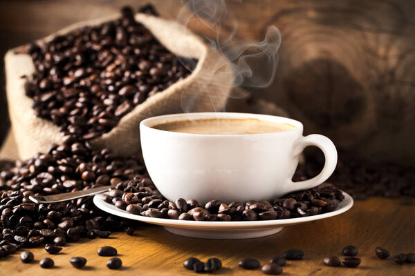 cup of coffee and  cake on coffee beans.