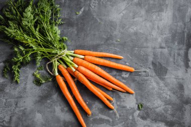 Taze havuç beton arka plan üzerinde yeşil yaprakları ile demet. Sebze. Gıda