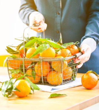 Kadın elleriyle demir sepeti taze clementine kopya alanı ile