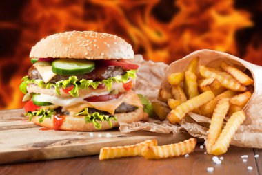 Fast food hamburger ve kızarmış patates ahşap arka plan üzerinde