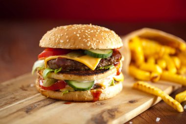 Fast food hamburger ve kızarmış patates ahşap arka plan üzerinde