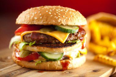 Fast food hamburger ve kızarmış patates ahşap arka plan üzerinde