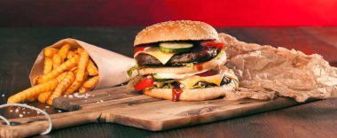 Fast food hamburger ve kızarmış patates ahşap arka plan üzerinde