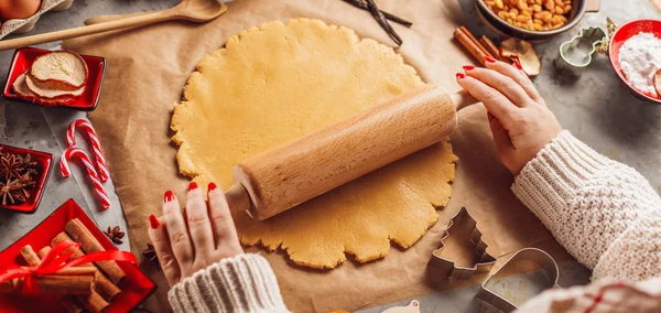 Christmas food concept. Woman is cooking gingerbread man cookies in Christmas close up.