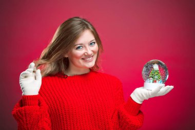 Yan kapatmak kar küresi tutan neşeli bir genç kadın portresi