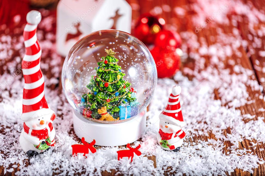 Christmas snow globe on wooden background