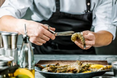 Şef ile koyu arka plan üzerinde kaplan karides pişirme 