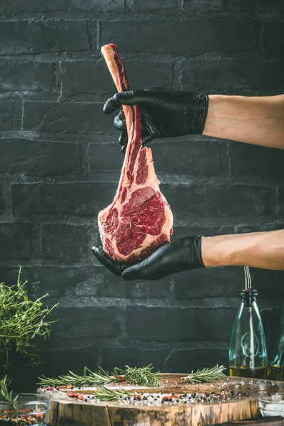 Mãos Masculinas Açougueiro Cozinheiro Segurando Bife Vaca Tomahawk Fundo Mesa — Fotografia de Stock