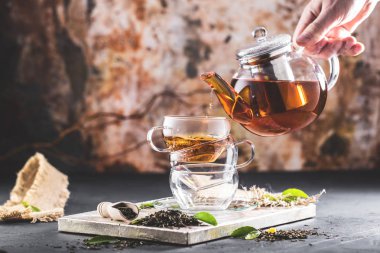 Taze demlendi siyah çay, sıcak yumuşak ışık, koyu arka plan.