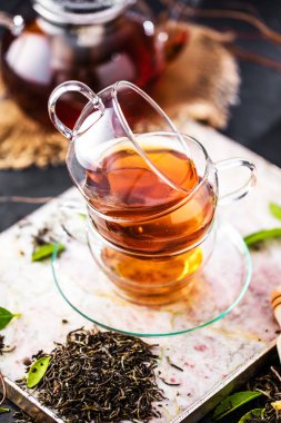 Taze demlendi siyah çay, sıcak yumuşak ışık, koyu arka plan.