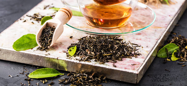 Чашка свежеваренного черного чая, теплый мягкий свет, темный фон
.