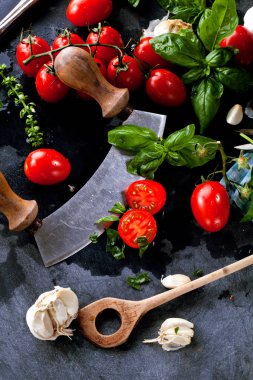 Taze domates fesleğen sarımsak ve deniz ile siyah arduvaz arka plan üzerine tuz.