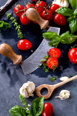 Taze domates fesleğen sarımsak ve deniz ile siyah arduvaz arka plan üzerine tuz.