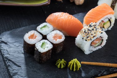 Suşi Sashimi ve suşi ruloları taş levhada servis edilir.